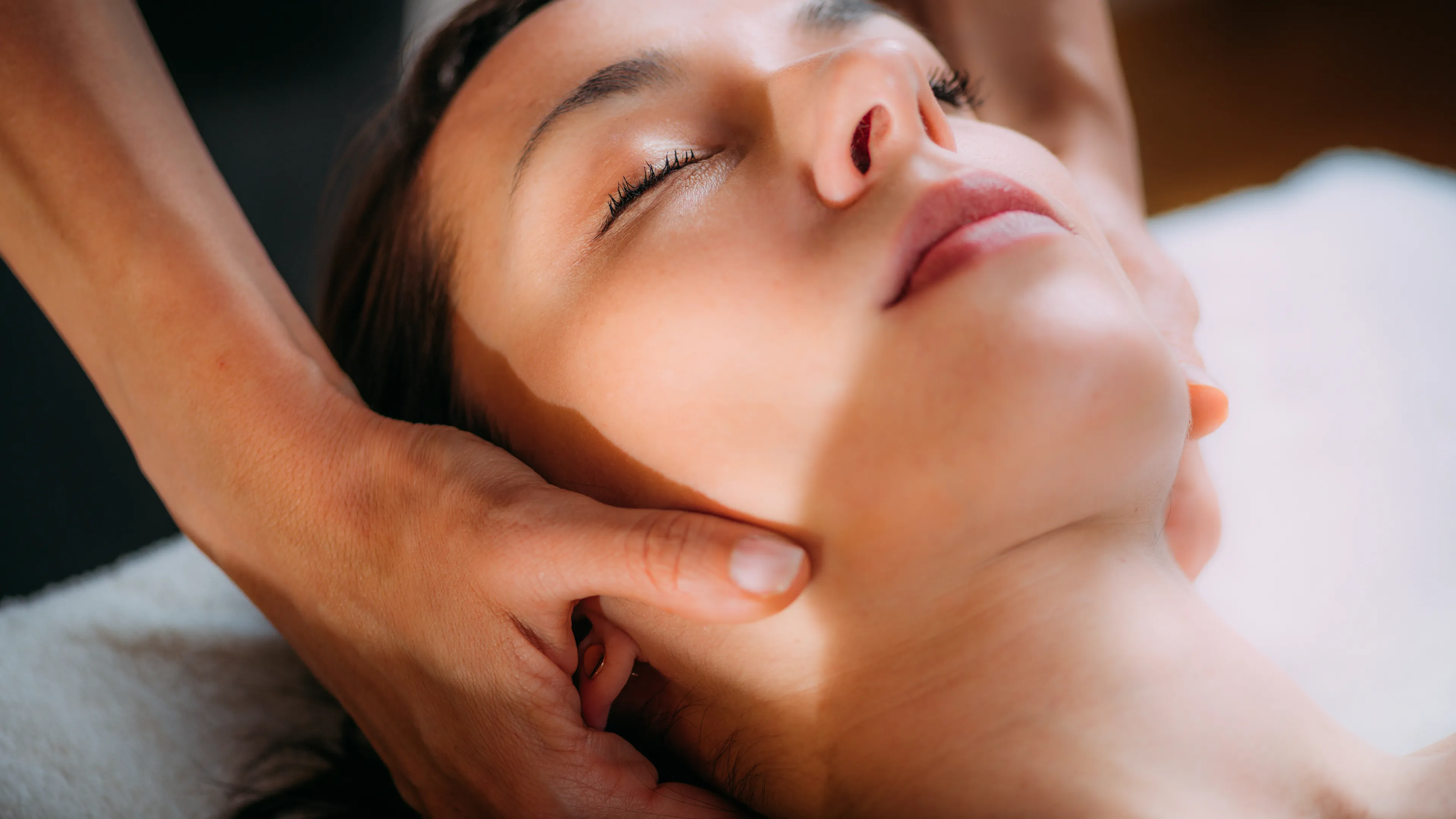 Zwei Hände berühren den Nacken eines Menschen